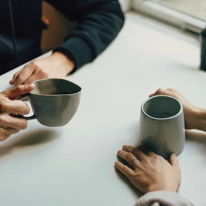 Two people sharing tea across a table
